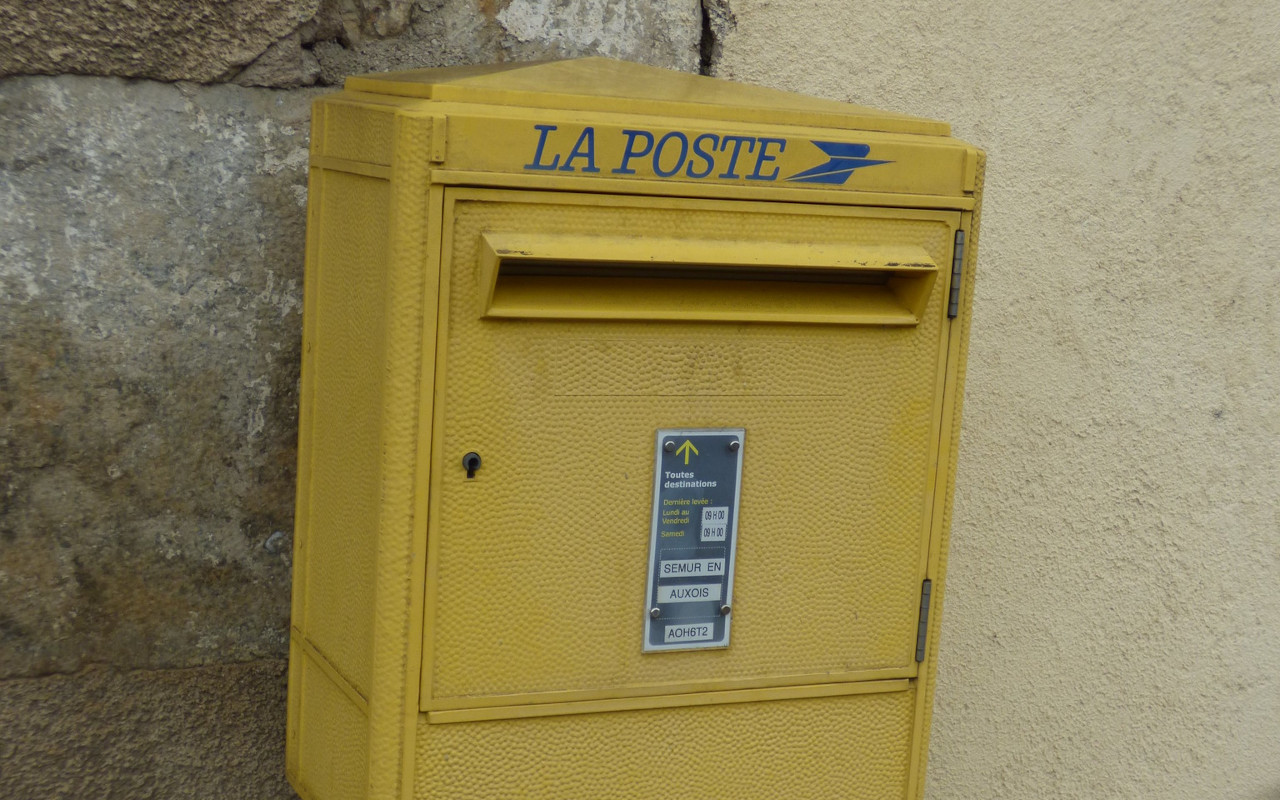 A photo of a yellow french postbox