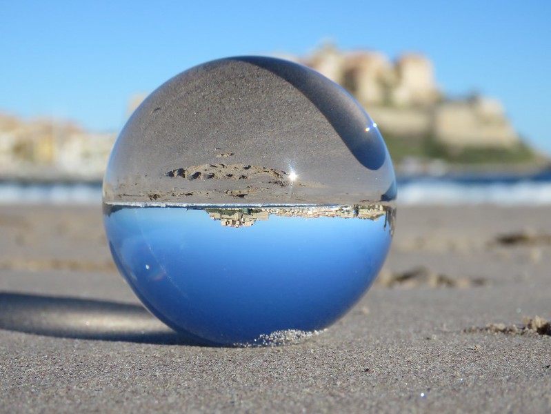 A photo of beach seen through a glass ball